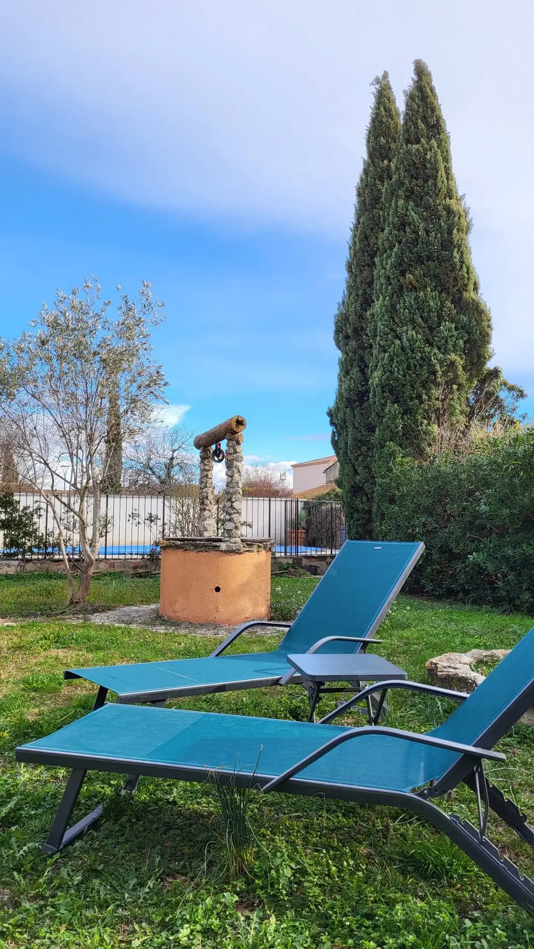 Le vieux puits en pierre et un bain de soleil dans le jardin