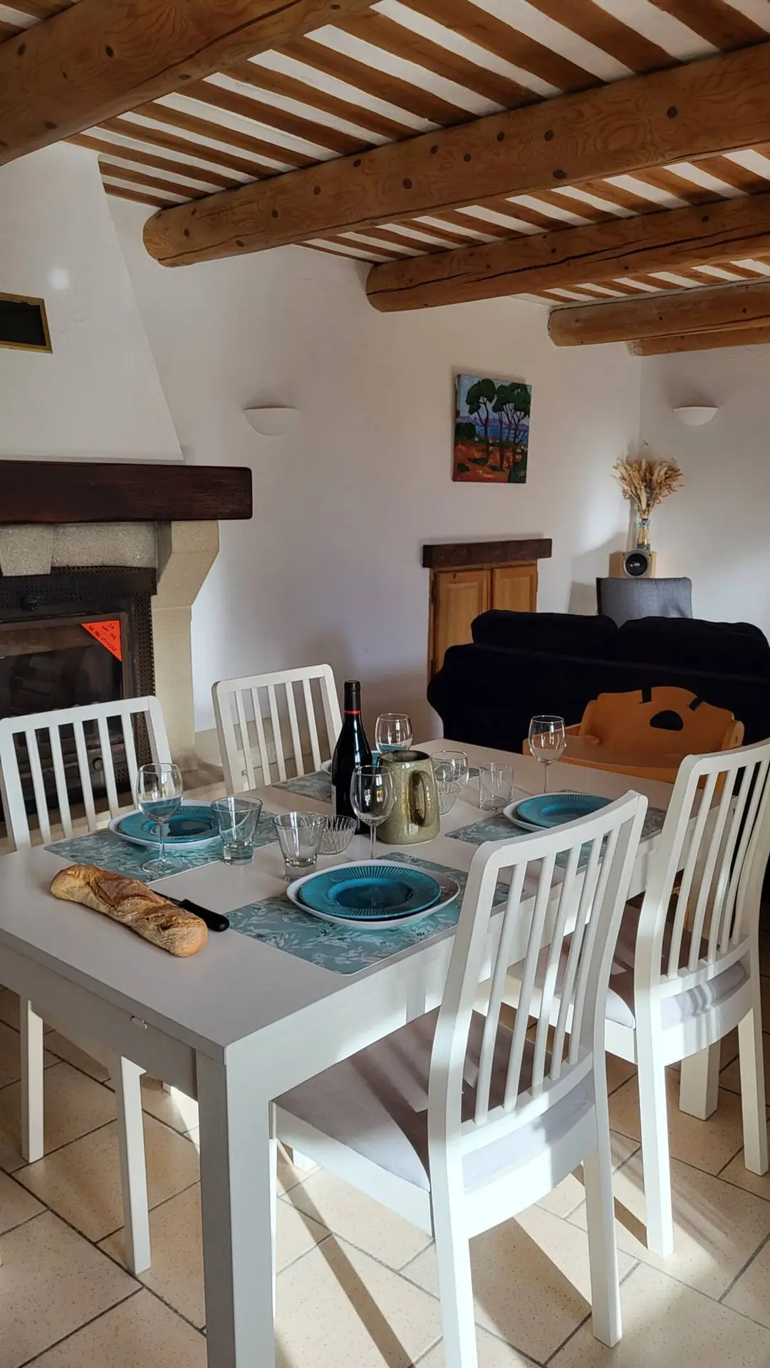 La table dressée devant la cheminée, le canapé en arrière-plan