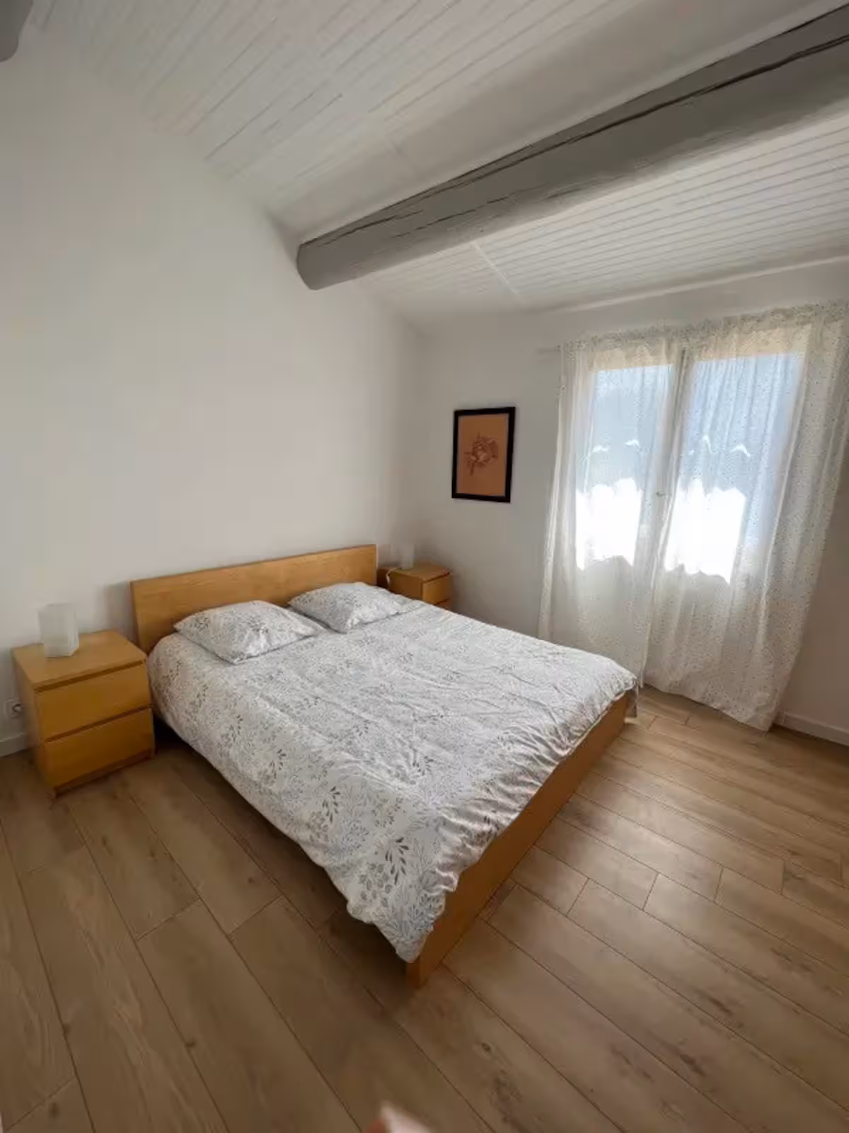 Une chambre avec lit double en bois